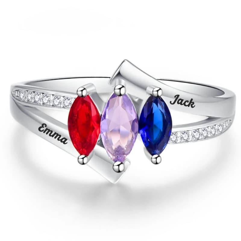 A silver ring featuring three marquise-cut birthstones in red, lavender, and blue, with engraved names “Emma” and “Jack” on the band and small clear stones along the sides.