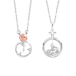 A pair of sterling silver couple necklaces. One pendant features a delicate rose with sparkling accents inside a circular frame, while the other shows a little prince figure sitting on a small planet beneath a star. Both are displayed on fine silver chains against a white background.