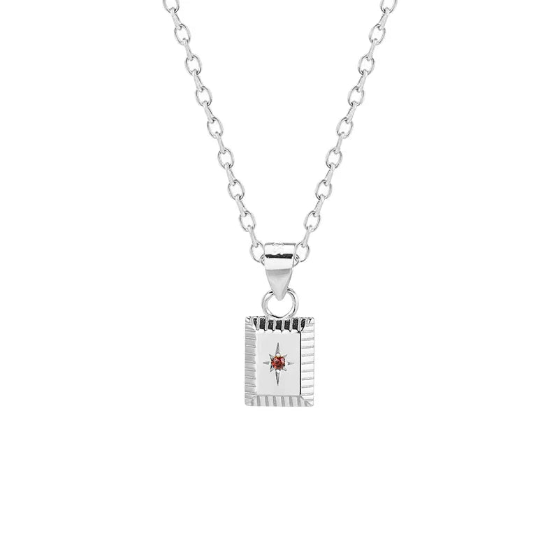 Silver necklace with a square pendant featuring a red gemstone on a white background