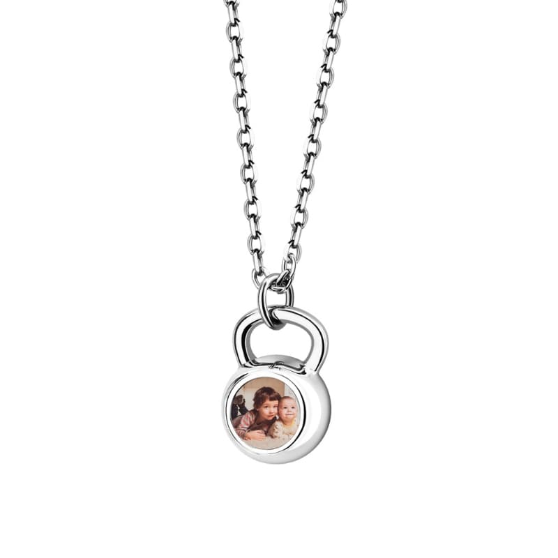 Silver necklace with a round pendant featuring a photo of two children on a white background