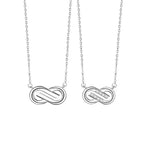 A pair of silver couple necklaces featuring Möbius loop pendants — one with a sleek polished finish and the other accented with small sparkling stones, displayed on a white background.