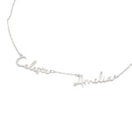 A silver personalized necklace featuring two connected names, “Celeste” and “Amelia,” crafted in elegant cursive script on a delicate chain.