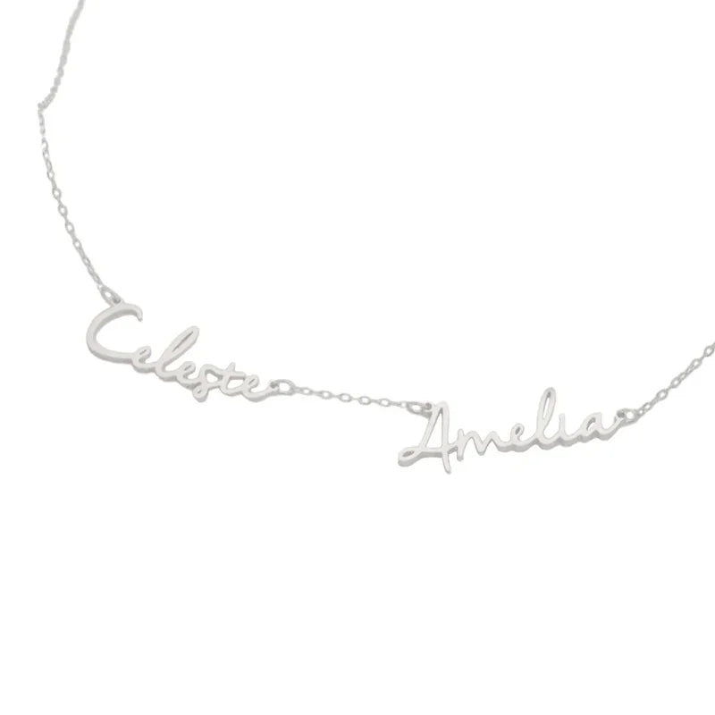A silver personalized necklace featuring two connected names, “Celeste” and “Amelia,” crafted in elegant cursive script on a delicate chain.