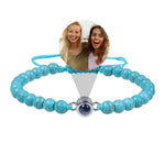 Turquoise beaded bracelet with a photo charm featuring two women on a white background